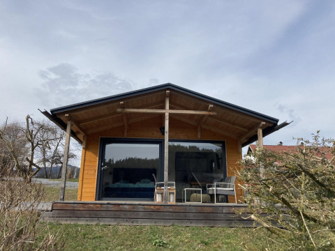 Lodge in legno con ampia veranda e grandi vetrate presso Stuga 2 al Wörthersee, Austria, di giorno.