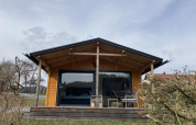 Een gezellige houten lodge met grote ramen en veranda bij Stuga 2 aan het Wörthersee in Oostenrijk.