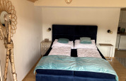 Room at Stuga 2, Wörthersee, Austria, showing two single beds, nightstands, and wooden decor details.