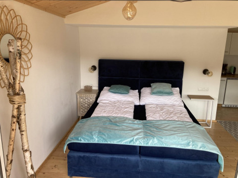 Chambre à Stuga 2 au Wörthersee, Autriche, avec deux lits simples, tables de nuit et décor en bois.