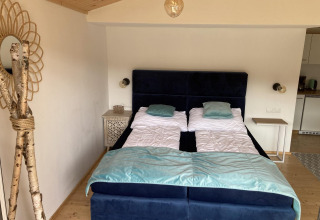 Chambre à Stuga 2 au Wörthersee, Autriche, avec deux lits simples, tables de nuit et décor en bois.