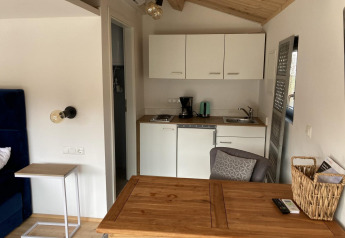 Gemütliches Interieur in Stuga 2 der Wörthersee Lodge mit Küchenzeile und Holztisch.
