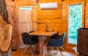 Interior de una acogedora casa en el árbol en Wörthersee, Austria, con paredes de madera y muebles modernos.