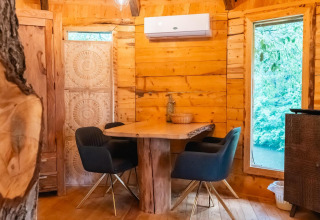 Interior de una acogedora casa en el árbol en Wörthersee, Austria, con paredes de madera y muebles modernos.
