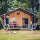 Familie foran en safaritelte ved Veluwepark de Bosgraaf i Holland, spiller fodbold og nyder tiden sammen.