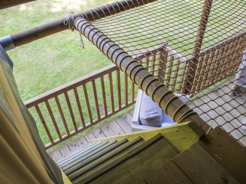 Zicht vanuit de Ranger Lodge safaritent in Veluwepark de Bosgraaf, Nederland, met terras en net zichtbaar.