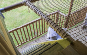 Udsigt fra Ranger Lodge safari-teltet i Veluwepark de Bosgraaf, Holland, viser træveranda og net.
