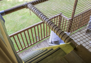 Blick aus dem Ranger Lodge Safarizelt im Veluwepark de Bosgraaf, Niederlande, auf Holztreppe und Netz.