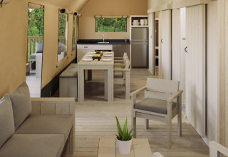 Interior de carpa safari Ranger Lodge en Veluwepark de Bosgraaf, Países Bajos, con muebles de madera rústicos.