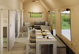 Vista interior de la tienda safari Ranger Lodge con comedor y sala de estar en Veluwepark de Bosgraaf, Países Bajos.