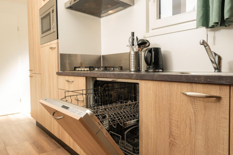 Keuken met open vaatwas, fornuis, gootsteen en waterkoker in Veluwe Lodge op Veluwepark de Bosgraaf, Nederland.