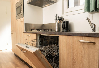 Keuken met open vaatwas, fornuis, gootsteen en waterkoker in Veluwe Lodge op Veluwepark de Bosgraaf, Nederland.