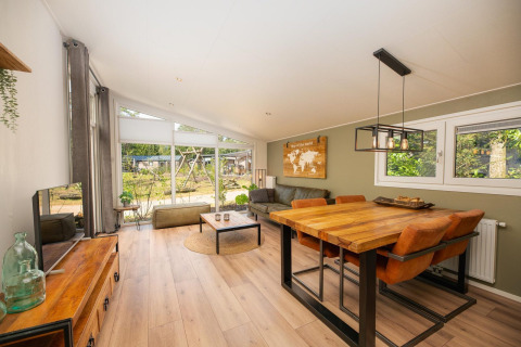 Helles, modernes Wohnzimmer in der Forest Lodge im Veluwepark de Bosgraaf, Niederlande, mit Holzmöbeln.