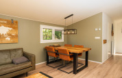Bright living area in the Forest Lodge at Veluwepark de Bosgraaf, Netherlands, featuring a dining table and chairs.
