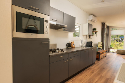 Cucina moderna alla Forest Lodge, Veluwepark de Bosgraaf, Paesi Bassi, con eleganti armadi grigi.