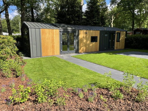 Moderna cabaña de madera con jardines cuidados en Cozy Chalet, Veluwepark de Bosgraaf, Países Bajos.