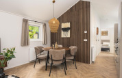 Essbereich in der Loevestein-Lodge im Veluwepark de Bosgraaf, elegante Holzakzente und gemütliche Atmosphäre.
