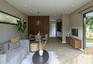 Modernes Wohnzimmer in der Loevestein-Lodge im Veluwepark de Bosgraaf mit elegantem Interieur und Gartenblick.