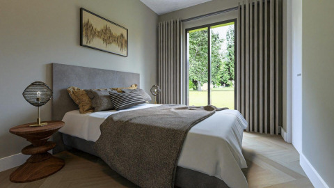 Dormitorio moderno en la cabaña Loevestein del Veluwepark de Bosgraaf, Países Bajos, con vistas al jardín.