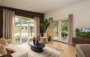 Woonkamer van de Loevestein Comfort lodge op Veluwepark de Bosgraaf met modern interieur en zicht op de tuin.