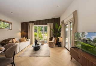 Sala de estar moderna en la cabaña Loevestein Comfort en Veluwepark de Bosgraaf, Países Bajos, elegantemente decorada.