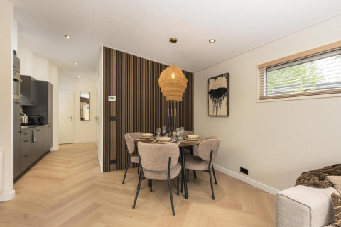Comedor y cocina de la Loevestein Comfort en Veluwepark de Bosgraaf, con decoración moderna y elegante.