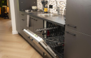 Moderne keuken met open vaatwasser bij Loevestein Comfort, Veluwepark de Bosgraaf, Nederland.