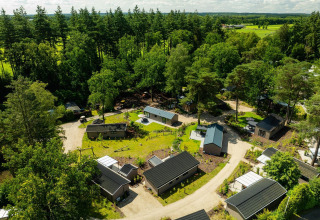 Vista aérea de la lodge Loevestein Comfort en Veluwepark de Bosgraaf, Países Bajos, rodeada de bosques verdes.