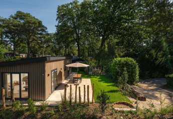 Moderne hytte Loevestein med spabad på Veluwepark de Bosgraaf, Holland, omgivet af smuk natur.