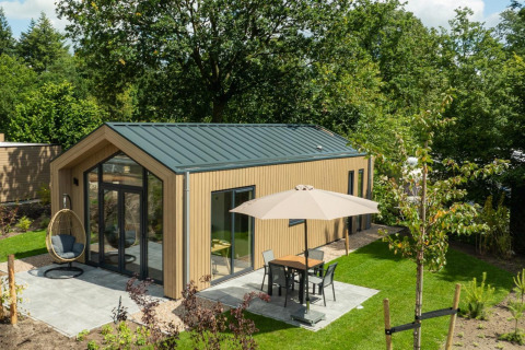 Foto de una moderna Tiny Lodge con terraza y sombrilla en Veluwepark de Bosgraaf, Países Bajos.
