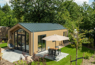 Foto de una moderna Tiny Lodge con terraza y sombrilla en Veluwepark de Bosgraaf, Países Bajos.