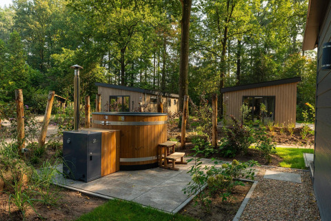 Tiny Loft con jacuzzi de madera al aire libre en Veluwepark de Bosgraaf, Países Bajos, rodeado de naturaleza.