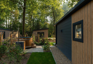 Cabañas Tiny Loft con jacuzzi exterior en Veluwepark de Bosgraaf, rodeadas de árboles en los Países Bajos.
