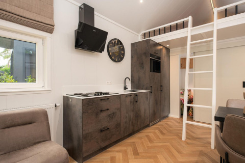 Cocina moderna y altillo en un Tiny Loft con jacuzzi en Veluwepark de Bosgraaf, Países Bajos.