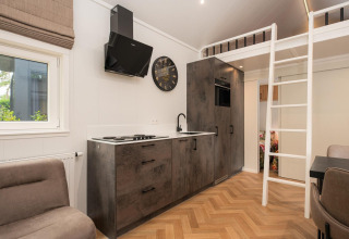 Cocina moderna y altillo en un Tiny Loft con jacuzzi en Veluwepark de Bosgraaf, Países Bajos.