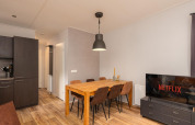Hyggelig spise- og stueområde med mørke møbler og TV, Sand Lodge Comfort, Veluwepark de Bosgraaf, Holland.