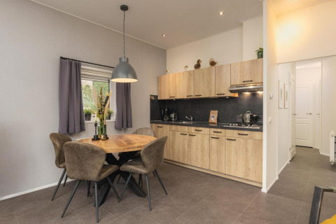 Cocina moderna y comedor en Heather Lodge en Veluwepark de Bosgraaf, Países Bajos, con detalles en madera.