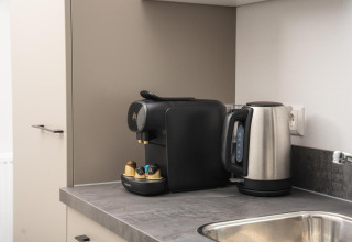 Cocina de lodge moderna con cafetera, hervidor eléctrico y fregadero en Velthorst Comfort, Veluwepark de Bosgraaf.