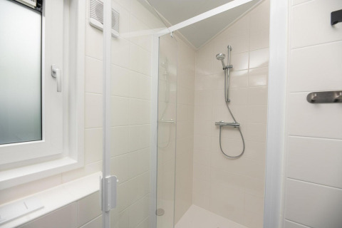 Moderna cabina de ducha con puerta de cristal y ducha regulable en Velthorst Comfort, Veluwepark de Bosgraaf.