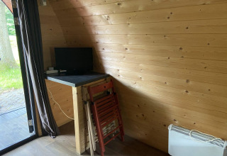 Piccola scrivania con monitor e sedie pieghevoli in un pod di legno a Het Amsterdamse Bos, Paesi Bassi.