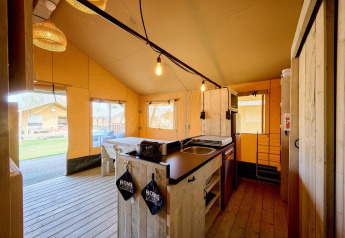Interior view of a safari tent Villatent Cottage with kitchen at Holiday Park Ackersate, Netherlands.
