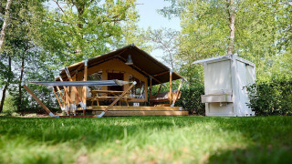 Tienda safari Villatent Compact con unidad sanitaria y hamaca en Recreatiepark de Lucht, Países Bajos.