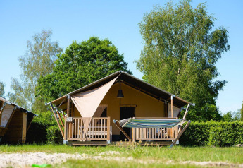 Tente safari Villatent Outback avec terrasse et hamac au Camping de Schatberg, Pays-Bas, ciel bleu.