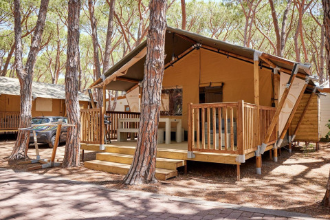 Alojamiento glamping Villatent Outback entre pinos, con terraza de madera y tienda de lona elegante