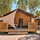 Safari teltet Villatent Outback ved Camping Laguna Blu i Italien med terrasse og hængekøje under træer.