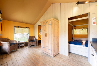 Interno della tenda safari Villatent Wood al Camping Nautic Almata in Spagna, con arredi in legno.