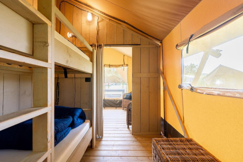 Vista interna di una tenda safari Villatent Wood con letti a castello presso Camping Nautic Almata in Spagna.