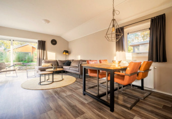 Lichte woon- en eetruimte in lodge Velthorst bij De Wije Werelt in Nederland, met moderne inrichting.
