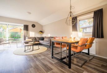 Salon et salle à manger lumineux au lodge Velthorst de De Wije Werelt, Pays-Bas, au mobilier moderne.