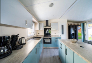 Moderne keuken in lodge Berkel, De Wije Werelt, Nederland, met lichte kasten en een keukeneiland.